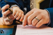 At Arnot Hill House, three sets of hands sign the wedding register, including the couple's little boy, creating a touching detail image that folds family into the official moment.