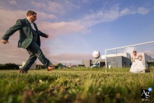 At the ceremony location in La Rochelle, France, the bride and groom take a break from their portrait session for a playful game of football, creating a fun, energetic image that reflects their personalities and the joy of the day.