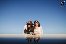 In Joshua Tree, California, the bride and groom take in the desert sunshine, creating a warm, relaxed wedding portrait with a blue sky behind them.