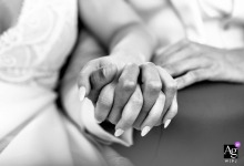 At La Pierre A Sel in France, a close-up detail captures the bride and groom's hands together, highlighting touch, rings, and the quiet intimacy of the wedding day.