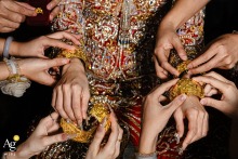 At the bride’s home in Zhanjiang, Guangdong, China, the bridesmaids help her put on traditional gold jewelry, while the many hands working together create a beautifully ordered composition filled with repeating shapes and graceful detail.