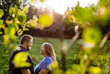 A photographer captures a romantic picture of a couple in Winterport, Maine, peering through vibrant fall foliage
