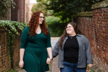 A couple walks hand in hand through a picturesque historic alley in Old Town Alexandria, VA, during their engagement photo session with a professional wedding photographer from WPJA