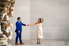A couple at the National Gallery of Art, DC readies for a portrait, as she fixes her hair and he holds her hand.