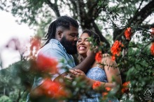 Capture the enchanting embrace, framed by vibrant flowers, during a pre-wedding engagement session in Maceió, Alagoas. Photographed by a WPJA professional, this portrait exudes warmth and romance.
