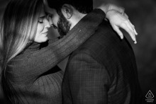 Close-up of couple embracing in warm setting sunlight during their engagement session at Graceland Cemetery.