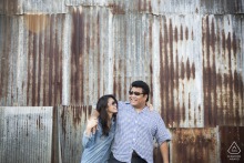 Stylish Sunglass-Clad Couple Pose by Rustic Rusted Metal Wall in Chantaburi, Thailand Couple wearing sunglasses pose against rustic, rusted metal siding in Chantaburi, Thailand, looking stylish.