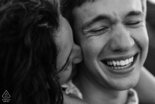 Couple laughing joyfully at Plymouth Rock, Massachusetts; a playful, candid portrait of love and laughter.