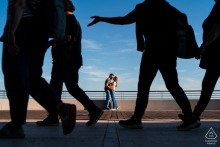 Couple’s portrait in Grado, Italy, framed by silhouettes of people walking in the foreground.