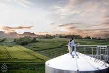Engagement portrait of a couple on Cognac cisterns at Vignoble du Cognaçais, France.