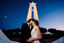 LISBON, Portugal — The couple share a romantic kiss at the Sanctuary of Christ the King, a powerful symbol of their love captured in this stunning engagement portrait high above Lisbon.
