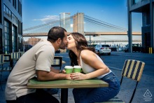 NEW YORK — A couple shares a cup of coffee near the Brooklyn Bridge, celebrating where their love began. This engagement portrait captures their heartfelt connection in a meaningful location.