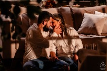 Engaged couple at Vale dos Ventos, Rio dos Cedros, SC: relaxing in a cabin, enjoying wine and intimate time together.