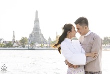 Minimalist Engagement: A Modern Romance in Old World Bangkok A couple stands together in Bangkok, Thailand, surrounded by old world buildings with clean light tones in the background. The minimalistic, modern setting highlights their sophisticated style in this engagement portrait.