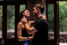 Loving Gaze Illuminated Under Overhead Light At Montreal’s Mount Royal Chalet Engagement At Mount Royal Chalet in Montreal, QC, Canada, a couple gazes lovingly into each other's eyes beneath a single overhead light, creating an intimate and romantic atmosphere for their engagement portrait.