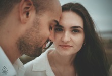Artistic portrait from Foz do Cavado, Esposende, Portugal, where a couple's eyebrows are aligned; the man is in soft profile focus while the woman behind him maintains an intriguing, fixed gaze at the camera.