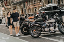 Stylish engagement photo capturing a couple in black attire walking past a row of parked motorcycles in a classic SoHo street scene, framed by construction scaffolding.