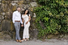 An intimate portrait of a couple set against a historic ivy-covered stone wall, captured within the serene, natural environment of the Arnold Arboretum in Massachusetts.
