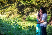 A couple is embraced or sharing an intimate interaction within the California wilderness. The expansive green foliage at Santa Cruz provides a sheltered, secluded atmosphere for their quiet display of affection.