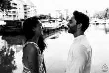 At Port de Ramonville, France, the couple stands face to face in profile by the water, captured in a black-and-white shot highlighting their quiet connection.