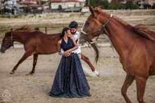 In Göreme, Nevşehir, Turkey, a Cappadocia pre-wedding photo session captures the couple standing embraced, surrounded by galloping brown horses.