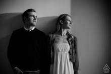 In the Catskills, New York, the couple stands side by side with backs to a clean wall, heads turned in profile, their shadows stretching across the surface in a striking black-and-white sunset shot.
