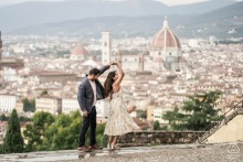 A couple dances playfully on a terrace overlooking Florence, with the iconic Duomo visible in the background, capturing their joyful connection against the historic city skyline.
