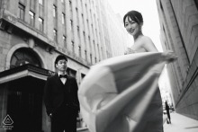 In a low angle black and white shot near the Peace Hotel on the Bund, Shanghai, her flowing dress and his steady stance evoke gentle strength and romance against the city’s iconic backdrop.