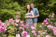 Soft pink spring blossoms frame an engaged couple sharing a close embrace during an outdoor session at Arnold Arboretum in Boston, Massachusetts.