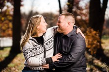 Warm smiles are exchanged as the cozy autumn warmth settles in around the couple during their romantic engagement session at the Carriage House at Rockwood Park in Wilmington, Delaware.