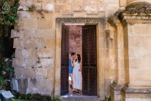 The couple share a quiet pre-wedding portrait at Iglesia de Santa María in Cazorla, Jaén, Spain, the stone architecture and surrounding greenery adding a timeless, serene touch to their engagement session.