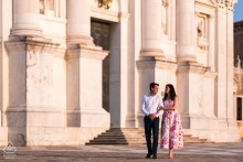 In Venice, Italy, a couple walks together along a street, with historic buildings adding to the composition of this portrait.