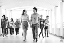 This couple portrait, captured in the vibrant city of Bangkok, Thailand, showcases the pair walking in the corridor with many other pedestrians.