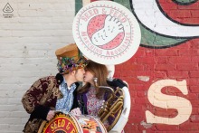 Sweet And Quirky Kiss Shared Under A Tuba At Manuel's Tavern For An Engagement Session In Atlanta Sharing a sweet and quirky kiss under a tuba at Manuel's Tavern in Atlanta, Georgia, this couple celebrates their unique personalities and musical interests during their indoor engagement session.