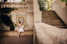 Pre-wedding engagement portrait of a couple beneath string lights at the Westin Riverwalk in San Antonio, Texas, with a sweeping staircase and tiled mural creating a dramatic backdrop.
