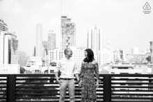 Black and white engagement portrait of an engaged couple overlooking the Bangkok skyline during a pre-wedding portrait session in Bangkok, Thailand.