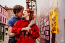 A couple embraces on a bustling street in Manchester City Centre, England, creating a candid and romantic pre-wedding portrait.