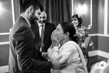At Offley Place in Hertfordshire, the groom enjoys a lively conversation with his excited grandmother during the festivities, creating a warm moment across generations.