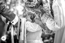 Inside Château LaSalle, France, a little girl, dressed as a bridesmaid, is caught crying, her heartfelt emotions standing out against the backdrop of the wedding celebration.