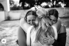 At Domaine de Saint Hypolite in Charente Maritime, France, the bride is warmly congratulated by her two bridesmaids immediately after the ceremony, sharing joyful embraces and excitement.