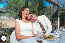 On a private ranch in Fillmore, CA, the groom leans in to his new wife during speeches, both laughing joyfully and sharing a look brimming with love and happiness.