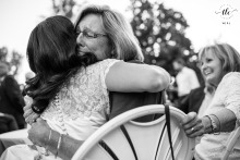 At a backyard wedding in Denver, Colorado, a bride is enveloped in a tearful and loving embrace by her aunt, emphasizing heartfelt family support on the big day.