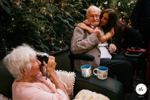 At Ever After Dartmoor in England, a grandfather receives a heartfelt embrace from his great-granddaughter while his wife joyously captures the moment with her camera.