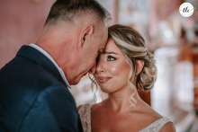 In the bride's family home in Lucera, Italy, father and daughter share an intimate and emotional gaze before leaving for the ceremony, savoring a meaningful pause together.