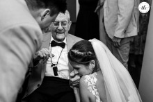 At Kasteel De Hooge Vuursche in Baarn, the bride lovingly bends forward to kiss her grandpa’s hand, his face glowing with a smile as the groom lovingly looks on.