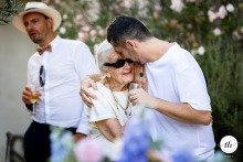 Amidst the festivities at Domaines des Patras in Solérieux, Drome, France, the groom lovingly embraces his grandmother, highlighting family bonds and generations coming together.
