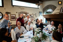 Guests mingle at El Dos Del Bec. The bride and groom kiss during their Pisogne, Italy, wedding reception. 