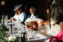 At Southwood Hall, Norwich, Norfolk, UK, the bride adorably hides her face in embarrassment during the groom's speech.