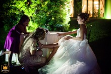 Guest helps bride remove shoes at La Catilina, Clusane d'Iseo, after the wedding party.