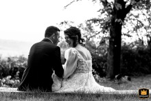 A WPJA wedding photo: A black and white shot from behind shows the couple sharing a candid laugh while sitting alone in Bertinoro old amphitheatre, Italy.